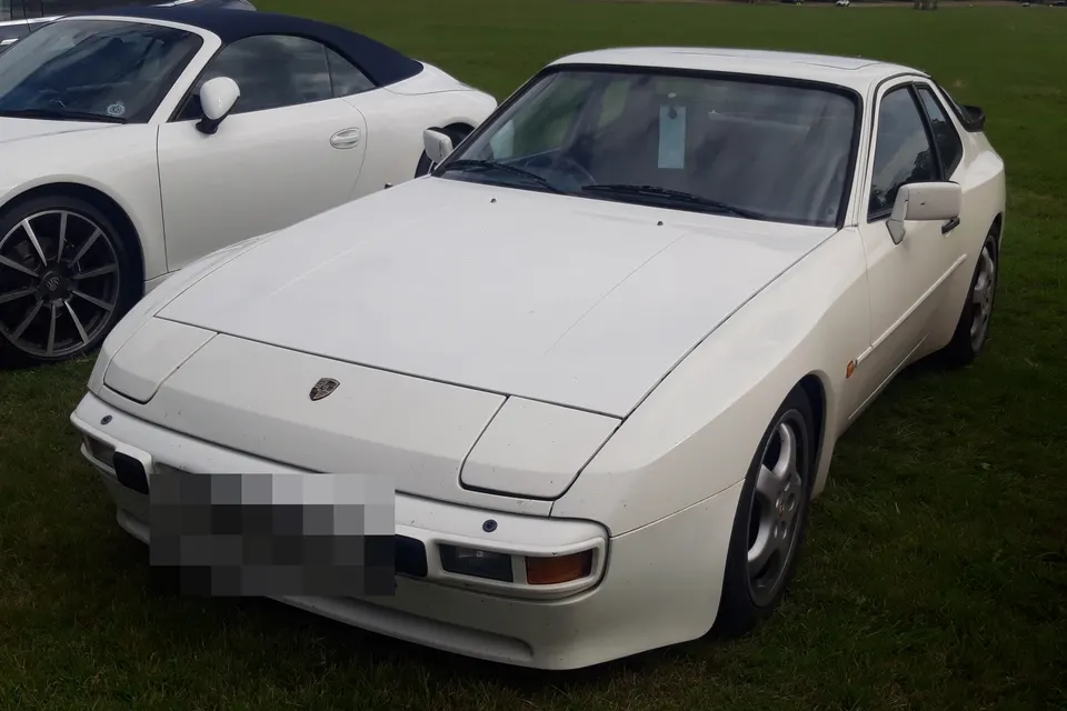White early Porsche 944 coupé, front three-quarter view