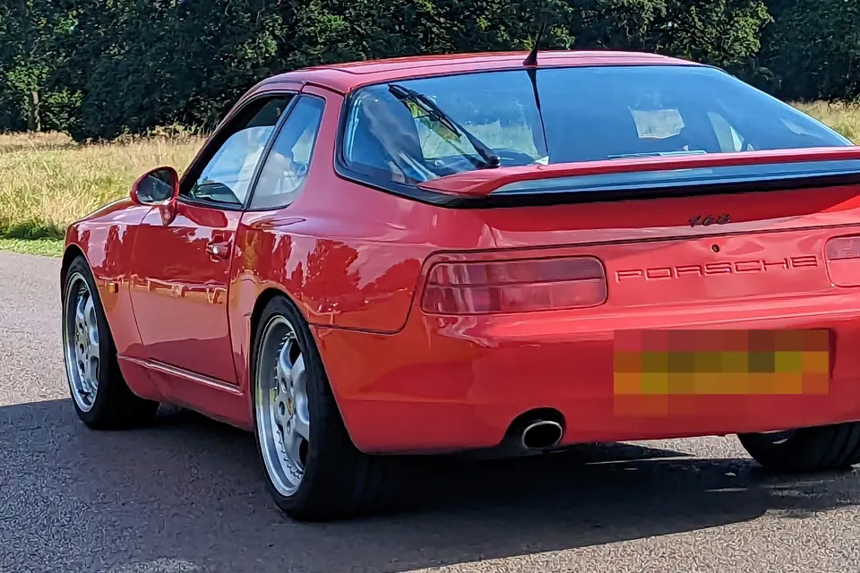 Red Porsche 968 coupé, rear three-quarter view