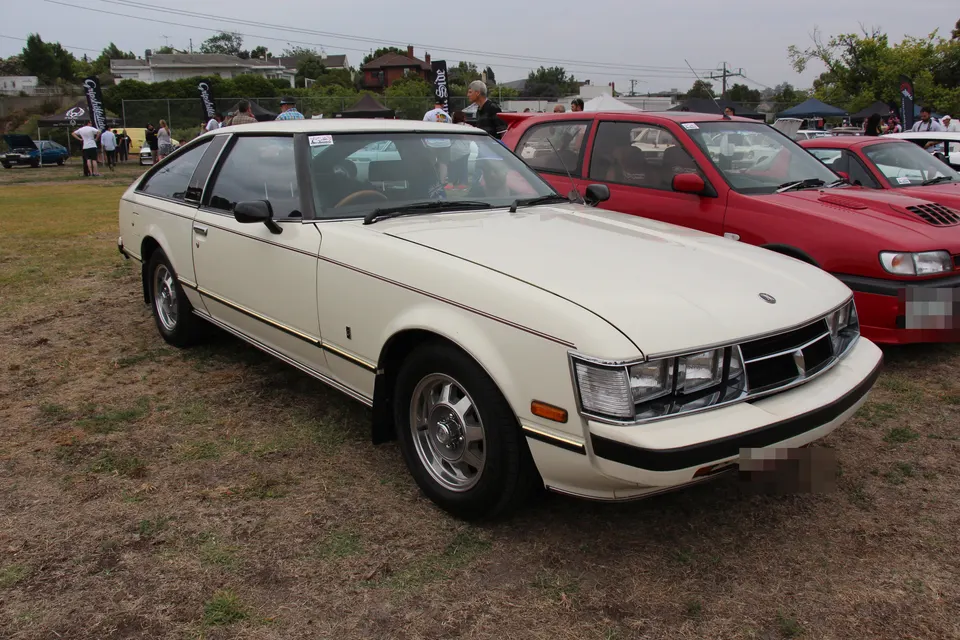 Cream first-generation Toyota Celica Supra A40 coupé, front three-quarter view