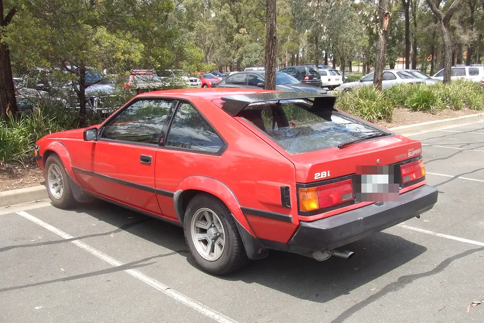 Red second-generation Toyota Celica Supra A60 coupé, rear three-quarter view