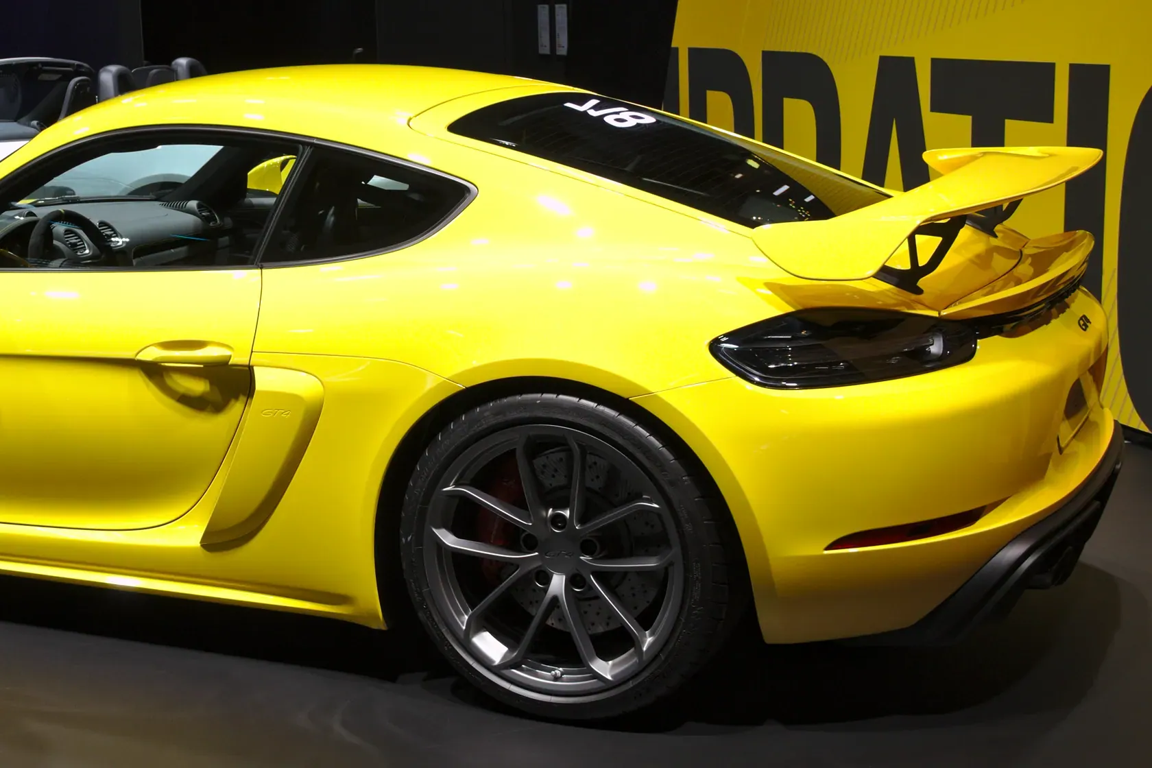 Yellow Porsche 718 Cayman GT4 Type 982 photographed from the rear three-quarter angle at IAA 2019