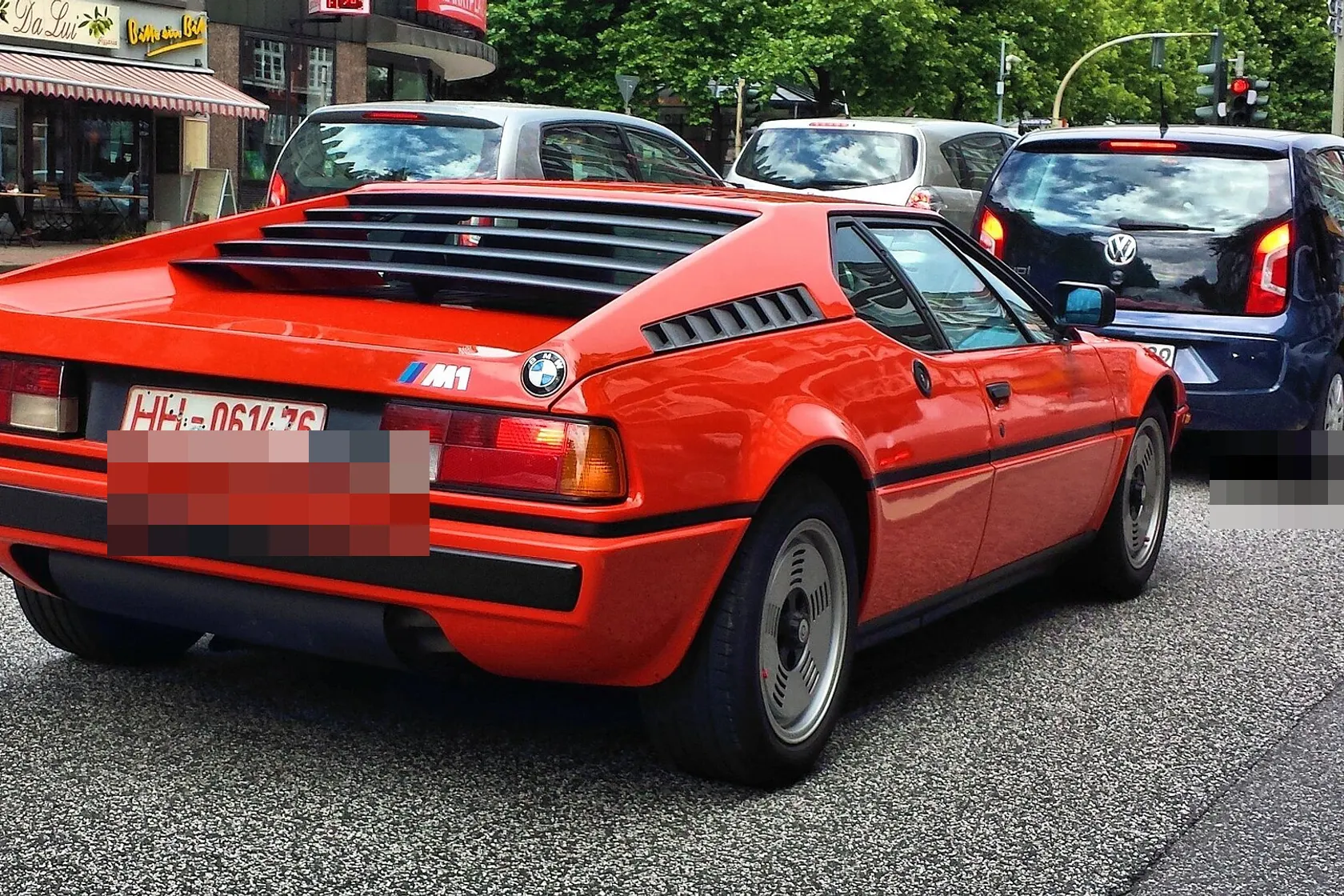 Red BMW M1 E26 photographed on a city street