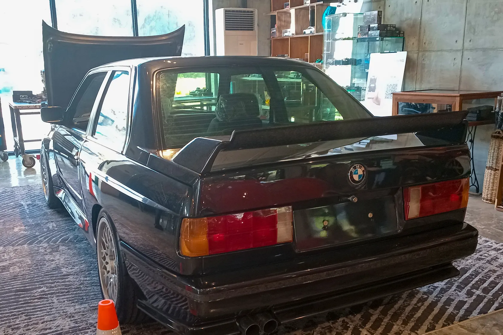 Black BMW M3 E30 road car seen from the rear