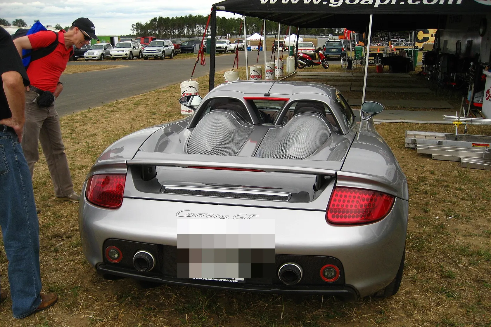 Silver Porsche Carrera GT photographed from the rear at an outdoor motorsport event