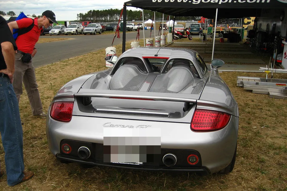 Silver Porsche Carrera GT photographed from the rear at an outdoor motorsport event