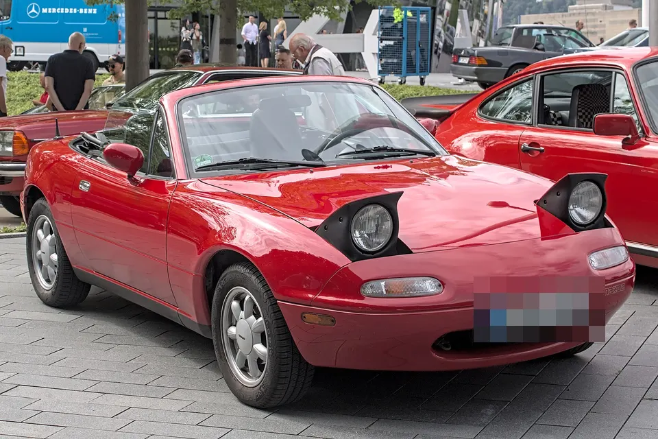 Red first-generation Mazda MX-5, front three-quarter view
