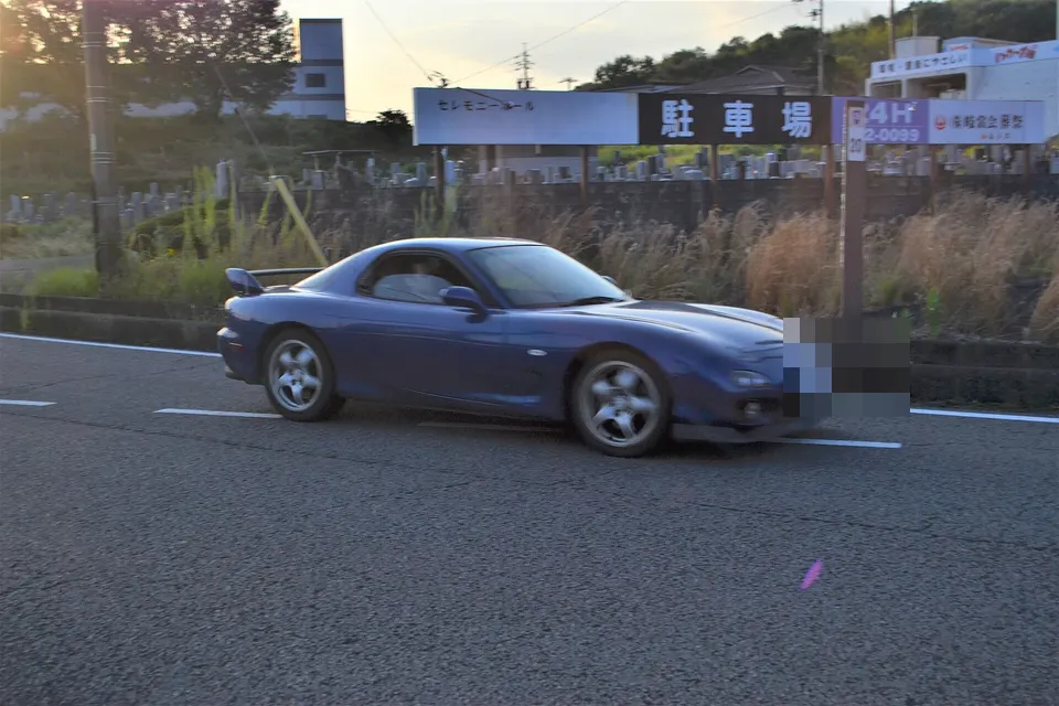 Blue Mazda RX-7 Type RS FD3S photographed from the front three-quarter in motion