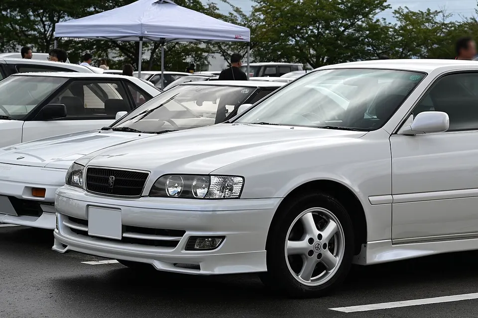 White Toyota Chaser Tourer V, side view; optional skirts and non-original clear corner light fitted